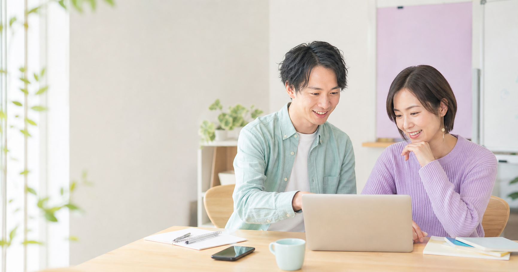 明るい教室で講師と受講者がノートパソコンを見ながらAI活用を学ぶ様子